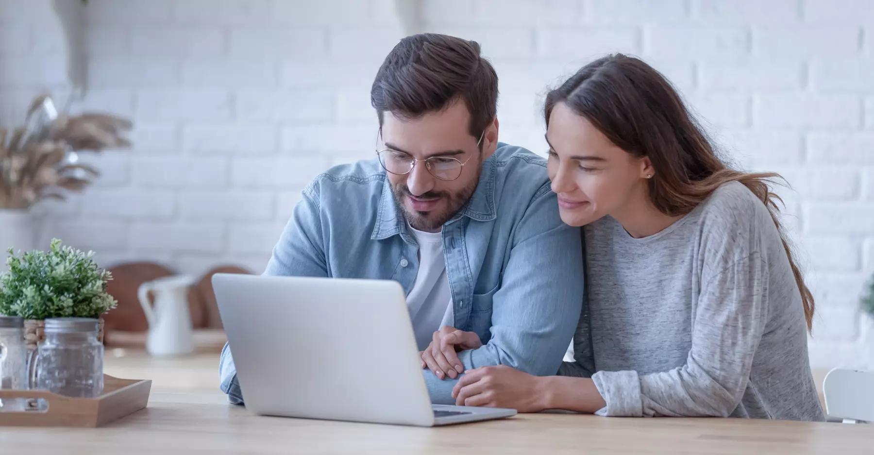 a couple sitting at a computer in their kitchen looking at biblically responsible investment pools