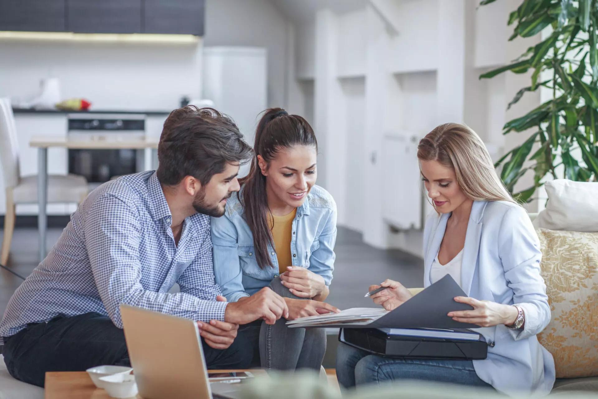 three people gathered around a table, reviewing a document