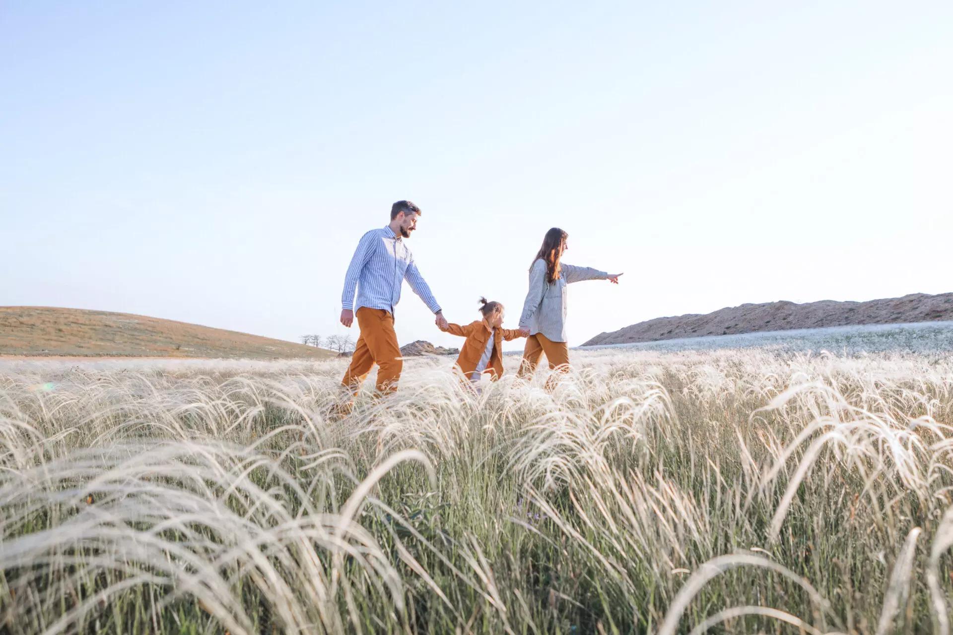 family of three walking on their land thinking of donating real estate