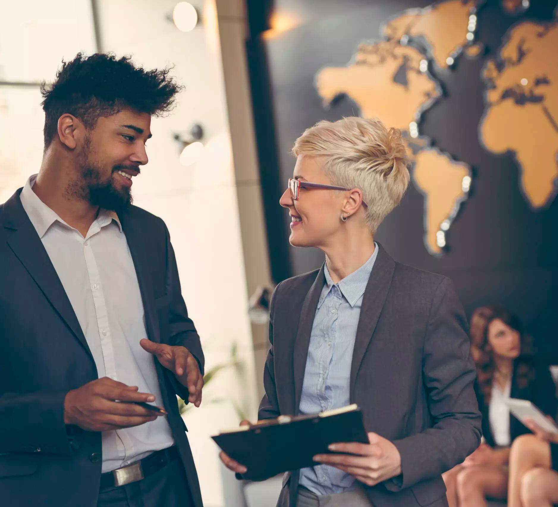 two professional people having a conversation in an office setting